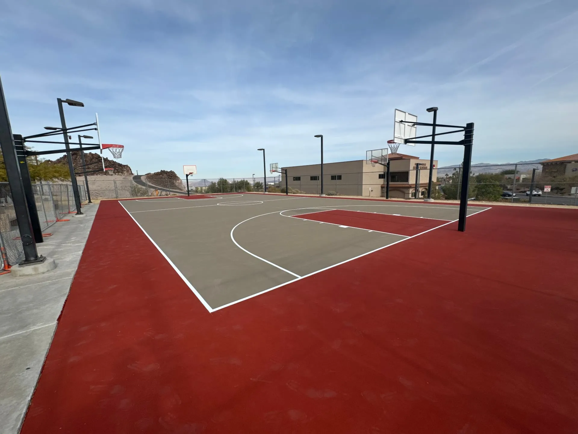 Newly surfaced post-tension concrete basketball court in Henderson Nevada with red and grey acrylic coating.