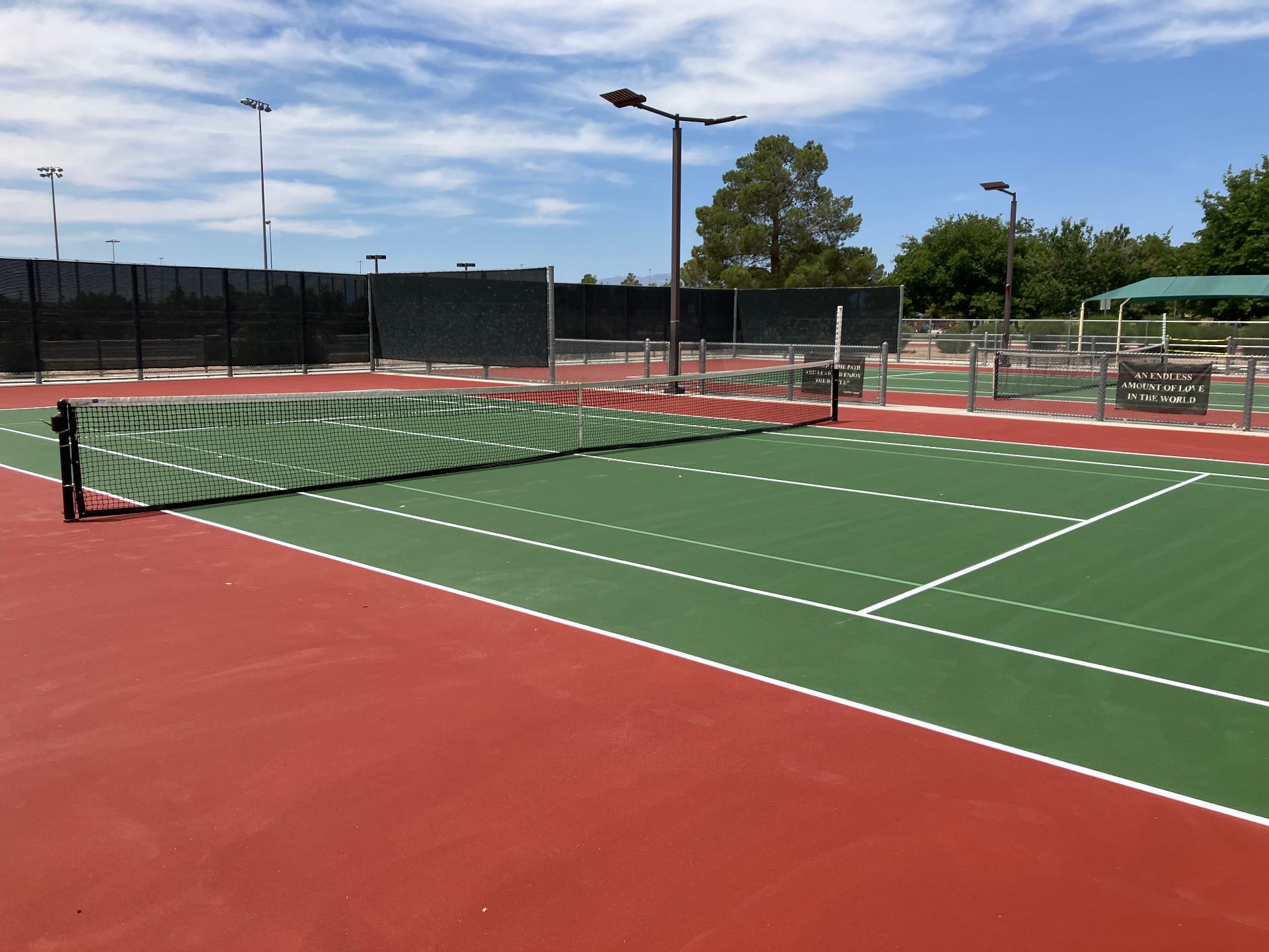 Professionally resurfaced green and red tennis court at an HOA community facility in Southern Nevada