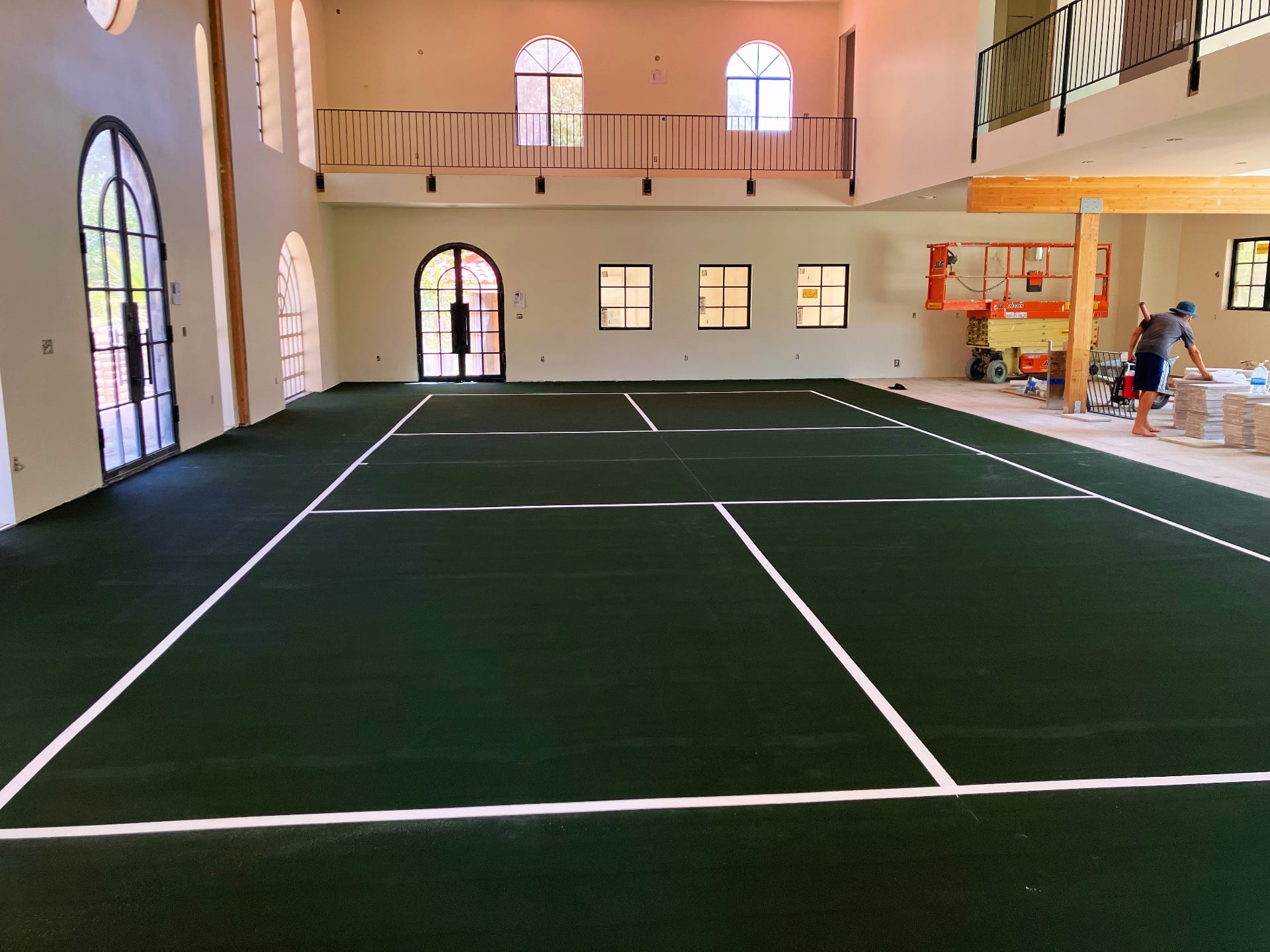 Newly surfaced indoor pickleball court with green flooring and white lines inside a large residential home in Las Vegas.