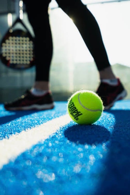 Padel racket on a blue court surface with padel balls in Las Vegas