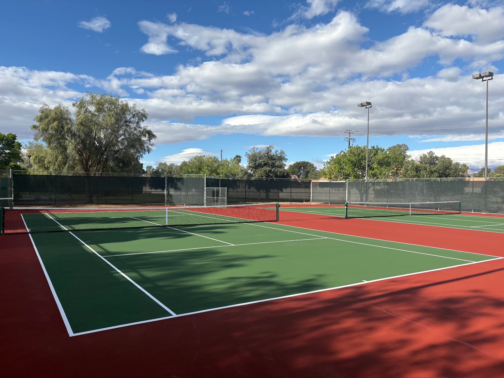 Newly resurfaced tennis courts at Childrens Memorial Park in Las Vegas with green and red acrylic coating.