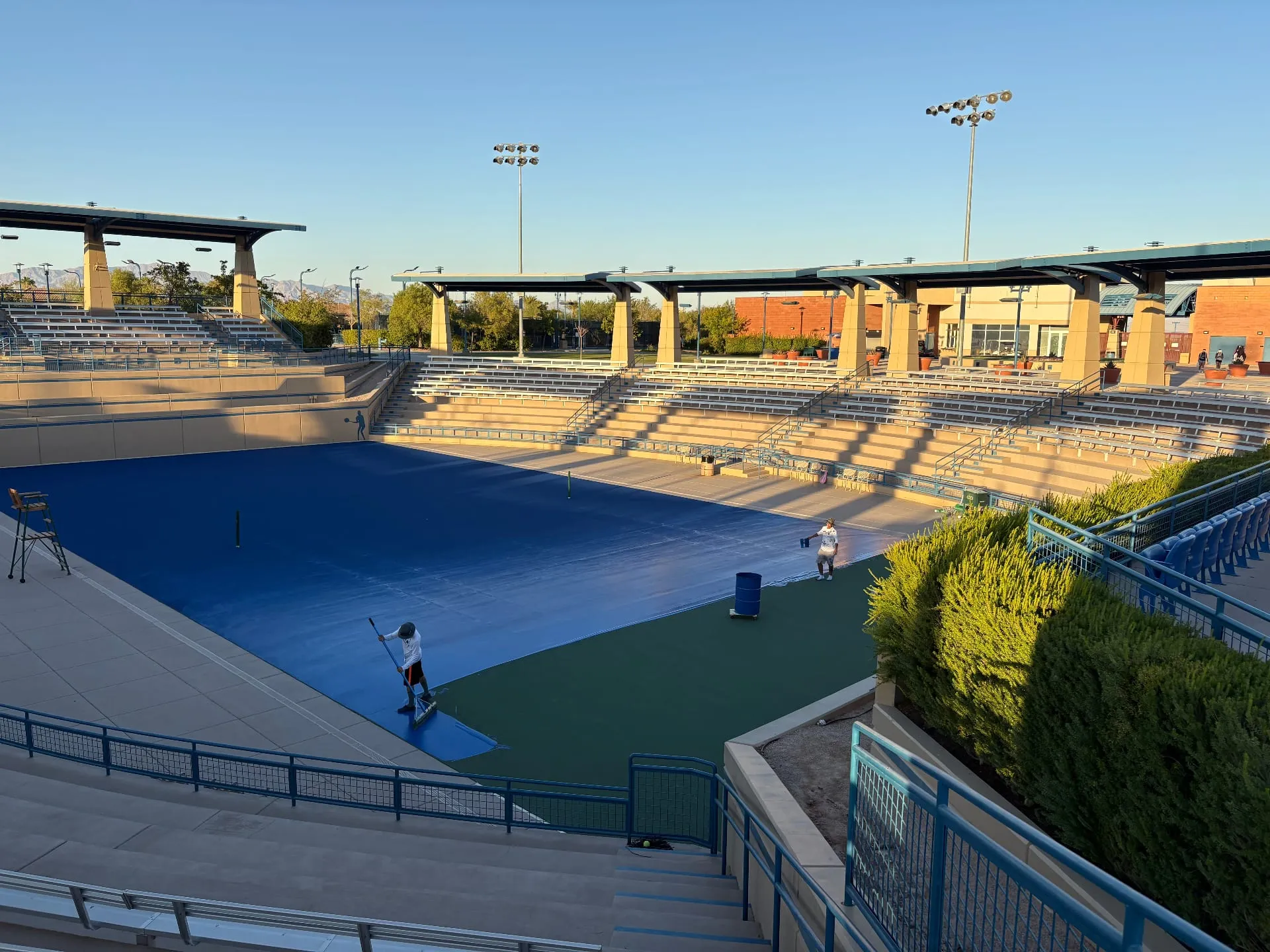 Crew applying acrylic color coating before striping a court in Las Vegas, NV