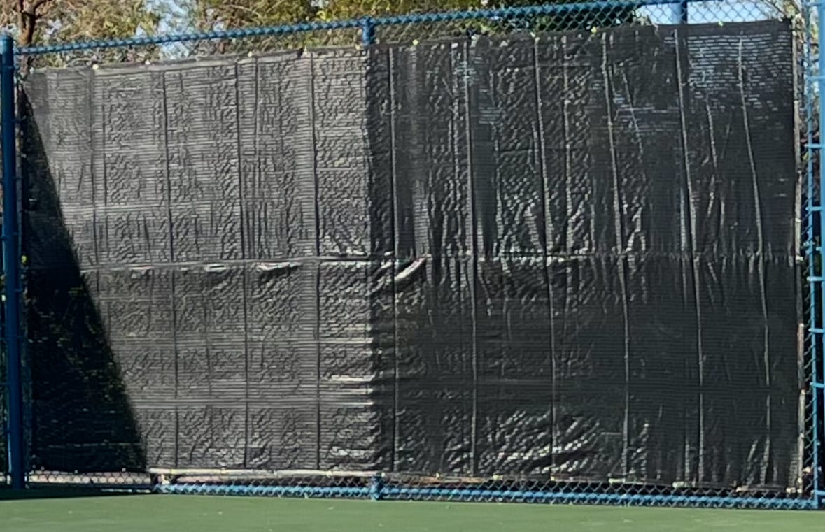 Black athletic court windscreen installed on a chain-link fence in Las Vegas